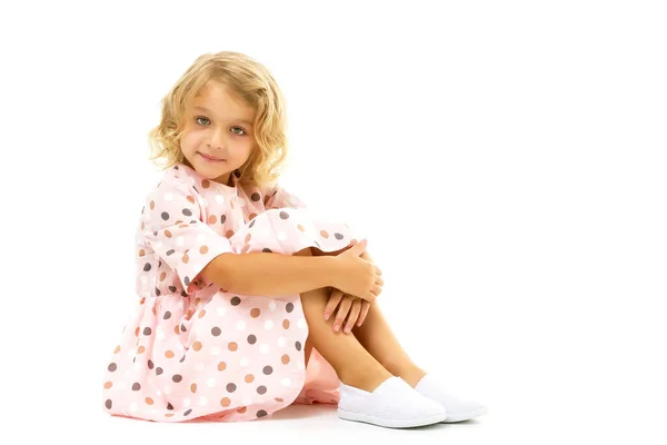 Niña está sentada en el suelo.El concepto de una infancia feliz. —  Fotos de Stock