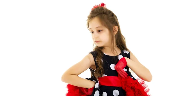 Menina encantadora em um vestido de bolinhas azuis com as mãos na cintura. — Fotografia de Stock