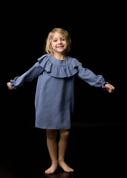 Mooi lachend meisje staande met armen uitgestrekt — Stockfoto
