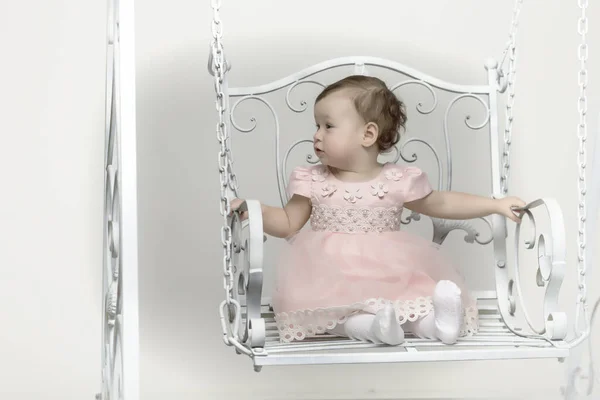 Feliz niña colegiala balanceándose en un columpio. — Foto de Stock