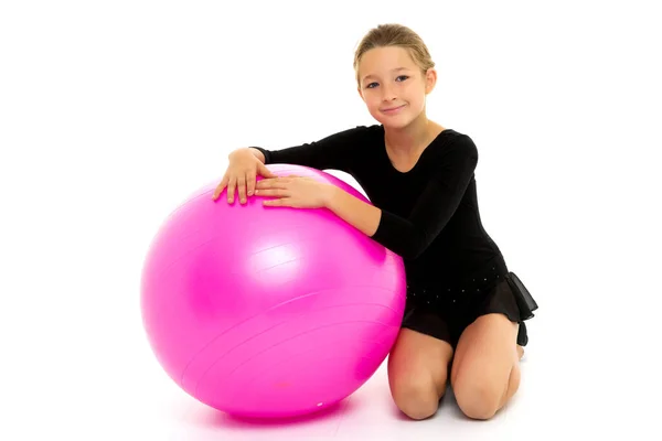 Niña haciendo ejercicios en una pelota grande para la aptitud. — Foto de Stock