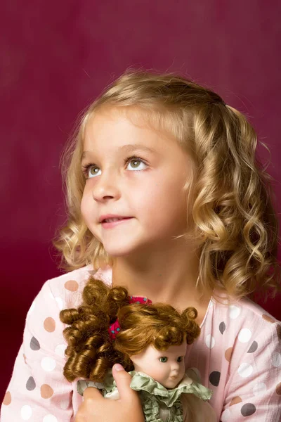 Schattig klein meisje spelen met een pop. — Stockfoto