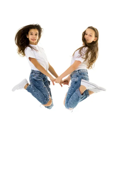 Два счастливых ребенка прыгают одновременно на белом фоне — стоковое фото