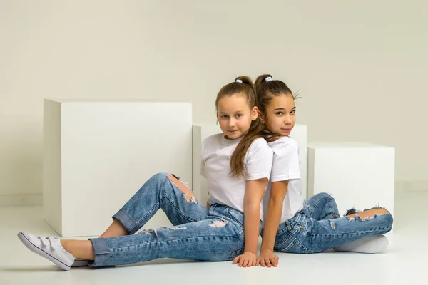 Dos niñas posando en el estudio sobre cubos blancos —  Fotos de Stock