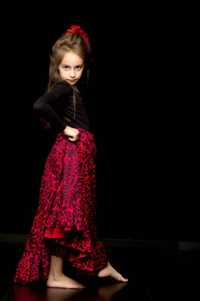 Обаятельная девушка в винтажном платье, танцующая на фоне черной студии. — стоковое фото