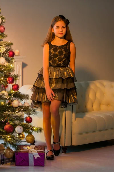 Girl in Stylish Dress Sitting on the Floor in Front of Christmas Tree. — Stock Photo, Image