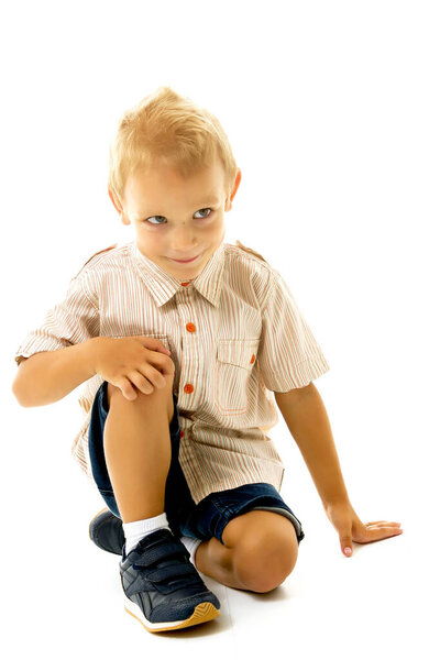 Portrait of young boy sitting isolated on white background