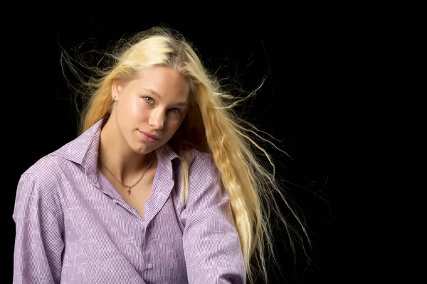 Ein schönes kleines Mädchen steht im Wind, ihre Haare und Kleider entwickeln sich stark. Das Konzept von Stil und Mode. — Stockfoto