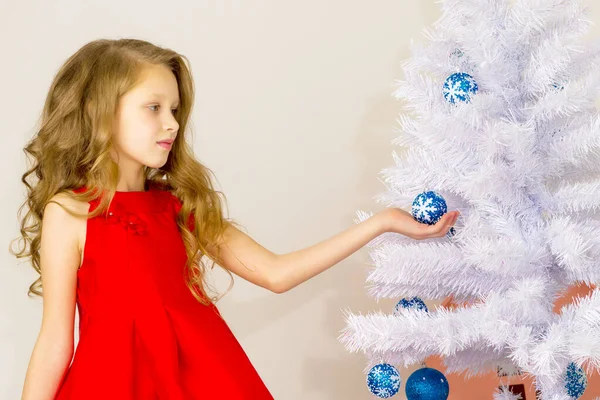 Meisje poseren naast witte kerstboom Holding Blue Bauble. — Stockfoto