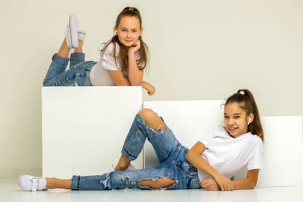 Dvě holčičky pózující ve studiu na bílých kostkách — Stock fotografie