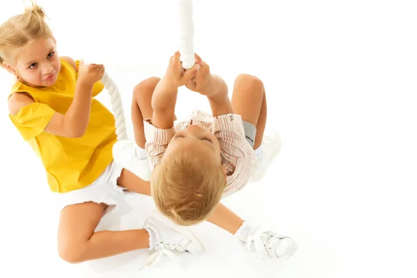 Um menino e uma menina seguram a corda com as mãos e escalam a corda. — Fotografia de Stock