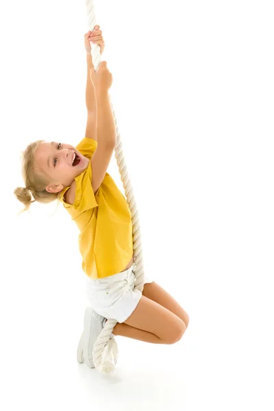 Uma menina segura a corda com as mãos, balançando sobre ele. — Fotografia de Stock