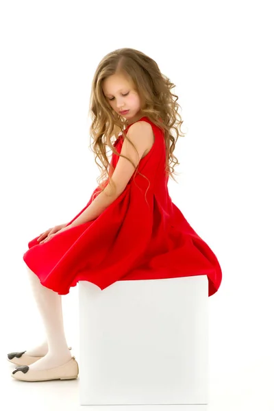 Linda menina loira em vestido vermelho posando na frente da câmera no estúdio. — Fotografia de Stock