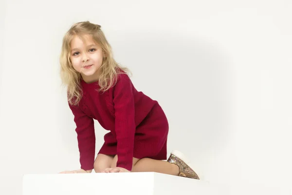 Schattig schattig blond meisje zitten op de vloer op haar knieën — Stockfoto