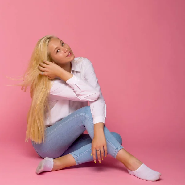 Chica adolescente posando en el suelo en el estudio. El concepto de estilo y moda. — Foto de Stock