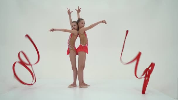 Két lány torna elvégzi a gyakorlatokat szalaggal. — Stock videók