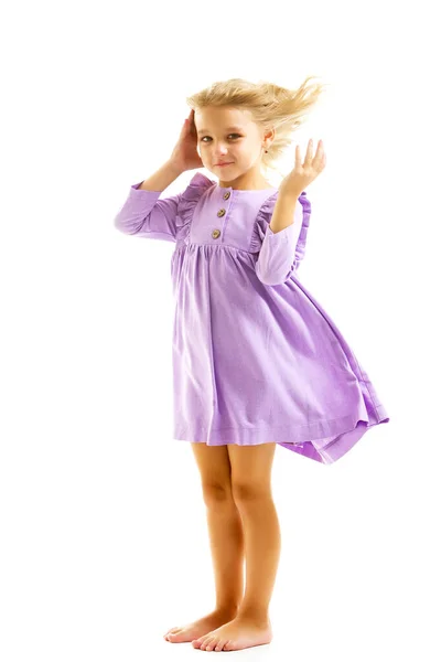 Una hermosa niña está en el viento, su cabello y su ropa se están desarrollando mucho. El concepto de estilo y moda. —  Fotos de Stock