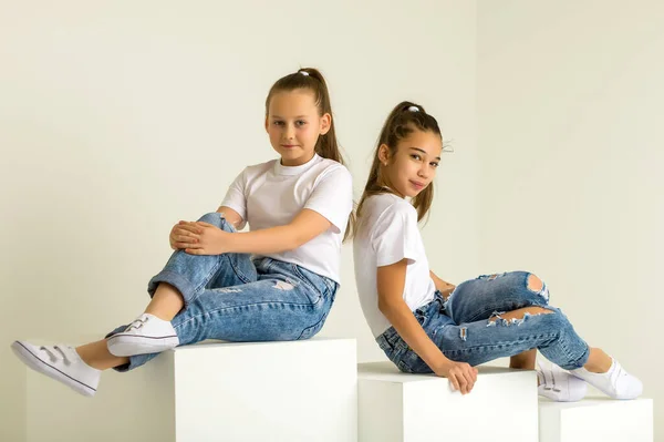 Dos niñas posando en el estudio sobre cubos blancos —  Fotos de Stock