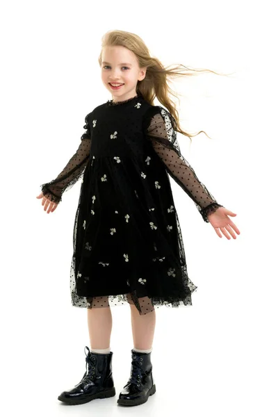 Una hermosa niña está en el viento, su pelo y su ropa. — Foto de Stock
