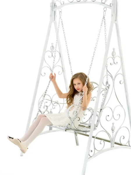 Menina loira em Nice Lace vestido sentado no balanço de metal elegante branco. — Fotografia de Stock