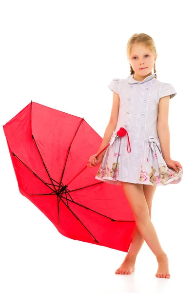 Klein meisje onder een paraplu.Concept stijl en mode. Geïsoleerd op witte achtergrond. — Stockfoto