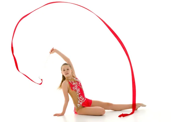 Dívka gymnastka provádí cvičení s páskou. — Stock fotografie