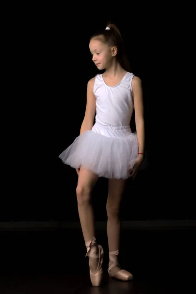 검은 배경으로 스튜디오에서 춤추고 있는 소녀가 투 투 투앤 포인트 신발을 신고 있습니다. — 스톡 사진