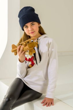 Küçük kız tahta bir uçakla oynuyor..