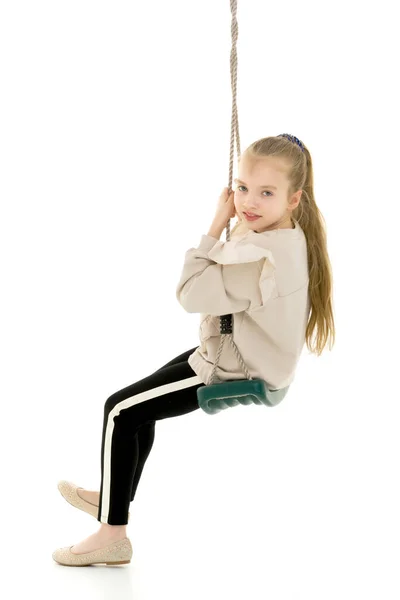 Gelukkig klein meisje schoolmeisje swinging op een swing. — Stockfoto