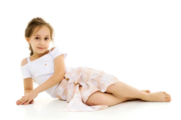 Прекрасна дівчина лежить на підлозі на білому тлі — стокове фото