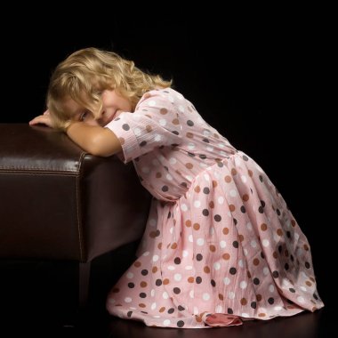 Küçük bir kızın portresi, o mutludur ve ellerini yanaklarına koyar. Parlak duygu.