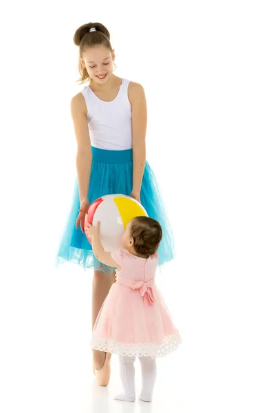 Graciös ballerina spelar boll med bedårande leende småbarn flicka. — Stockfoto