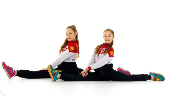 Сестри - близнюки у спортзалі Сидять на підлозі в горизонтальному ящику. — стокове фото