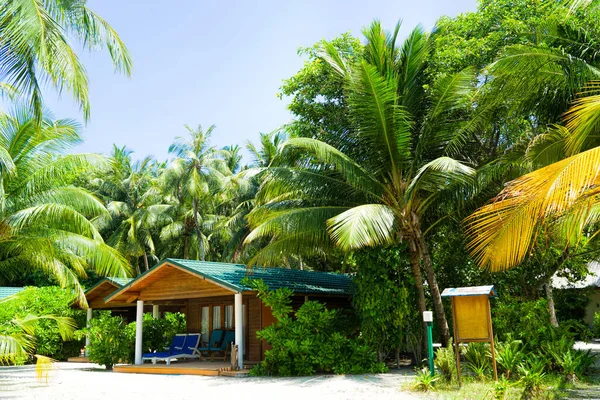 Puentes de madera que conducen a las cabañas a orillas del mar tropical y cálido. Maldivas. Concepto turístico. — Foto de Stock