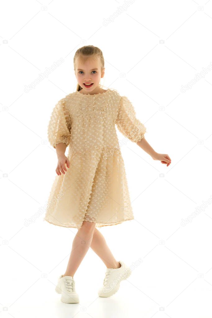 A cheerful little girl is dancing.The concept of a school of dance.