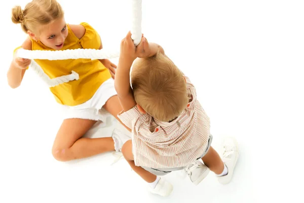 Een jongen en een meisje houden het touw vast met hun handen en beklimmen het touw. — Stockfoto