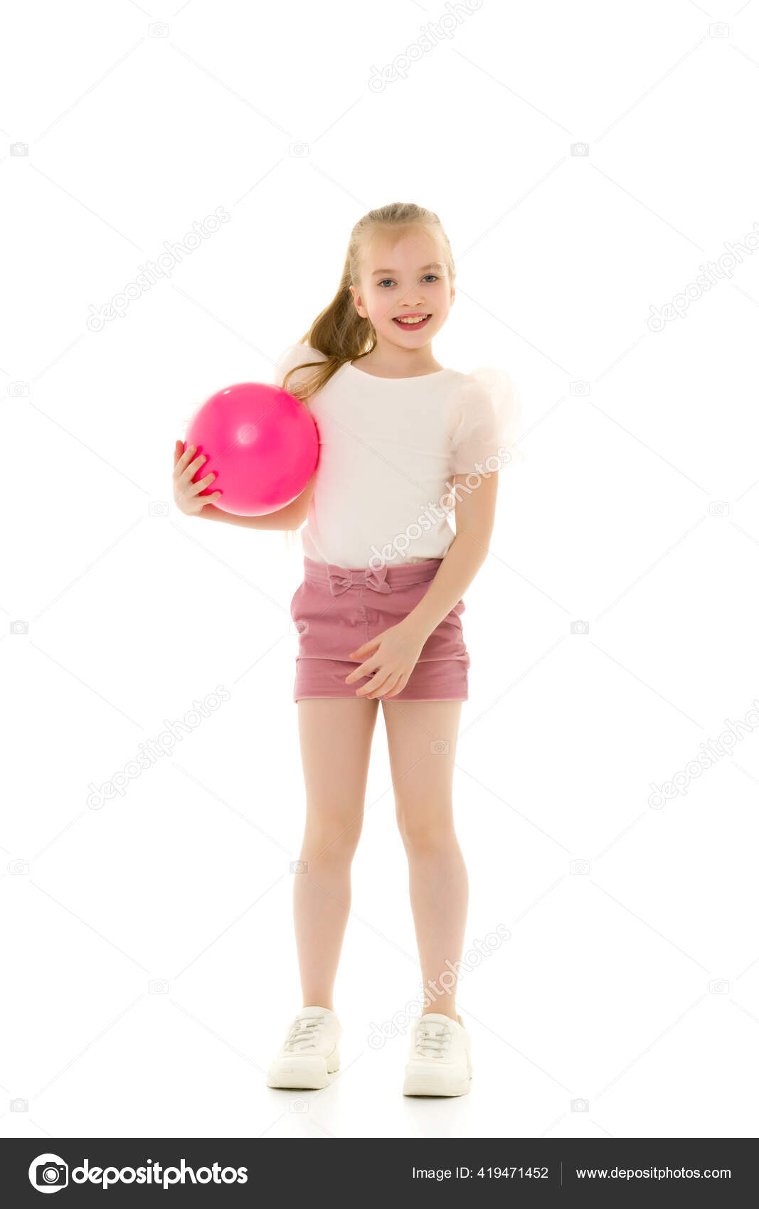 Little girl is engaged in fitness with a ball. Stock Photo by
