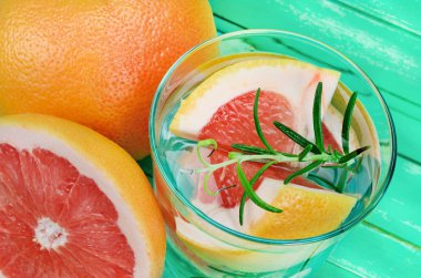 yeşil ahşap masa üzerinde greyfurt suyuyla cam