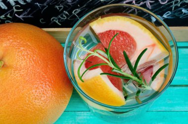 mavi ahşap masa üzerinde greyfurt suyuyla cam