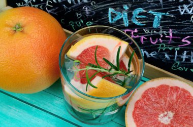 mavi ahşap masa üzerinde greyfurt suyuyla cam