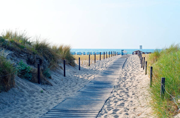 Пляж на немецком побережье Балтийского моря с пляжным шезлонгом и ощущение отдыха с песком
