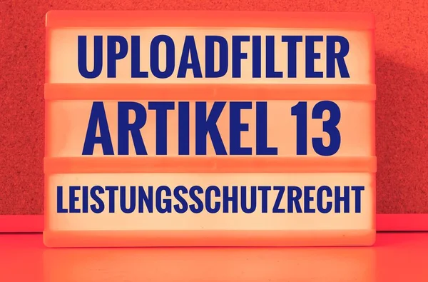 Illuminated panel with the german words Uploadfilter Artikel 13 Leistungsschutzrecht in english Upload filter Article 13 ancillary copyright