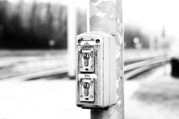 Lock of the signal system next to the train tracks in black and white
