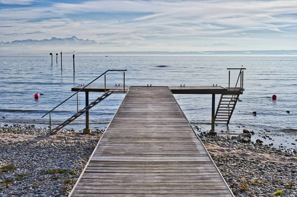 Boat dock on Lake Constance with a view of the Alps