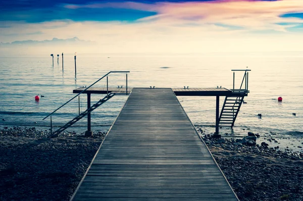 Boat dock on Lake Constance with a view of the Alps