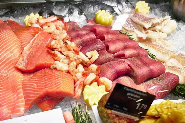 Fish fillets in a fish counter of a delicatessen with salmon, rollmops and inscription in german Fischfrikadellen und english Fish Meatballs