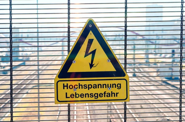 ドイツのホッホスパンヌン レベンスゲファールで警告を発する鉄道線路にサインする 英語高電圧の生命に対する危険性 — ストック写真