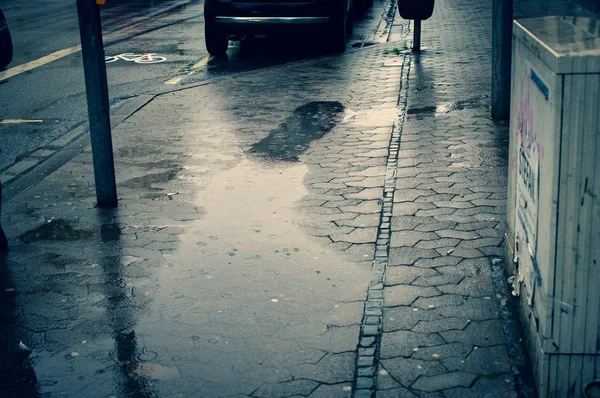 Wet road in a city with puddles of rain
