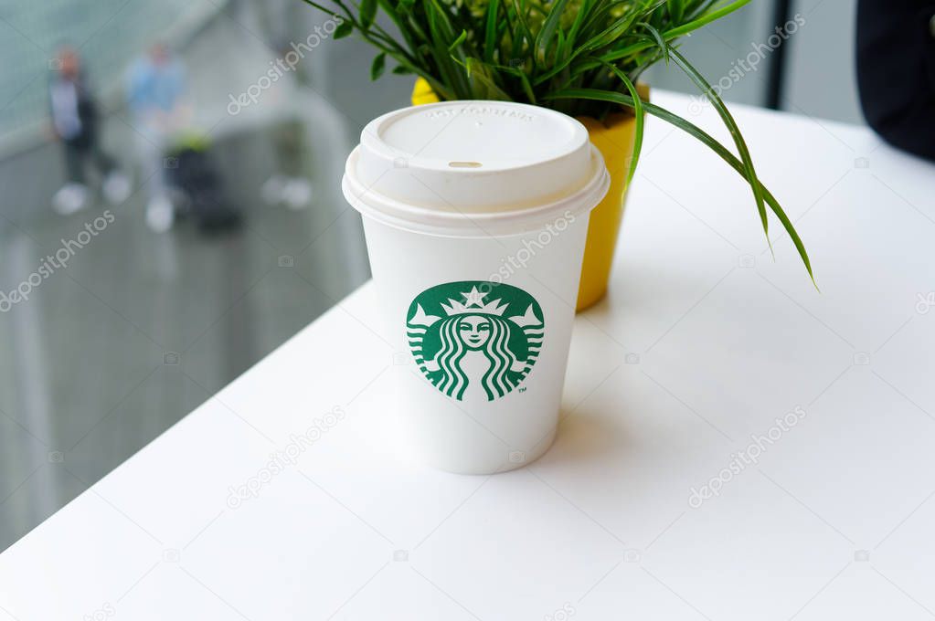 Starbucks Coffee-To-Go Mug with banderole on a white table to illustrate plastic waste in a Starbucks restaurant in Koblenz photographed on 2019.08.17