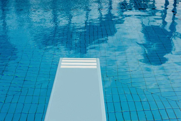 Piscina con refrescante agua azul, trampolín y reflejo —  Fotos de Stock